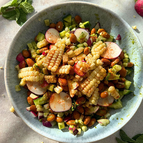 Summer vegetable dense bean salad with roasted corn, pinto beans, radishes, cucumbers, and a mint lemon honey vinaigrette